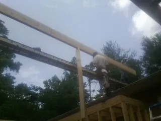Carpenter setting a ridge beam over a new addition frame — Ice Dam Removal by Roofing Brothers in Lancaster