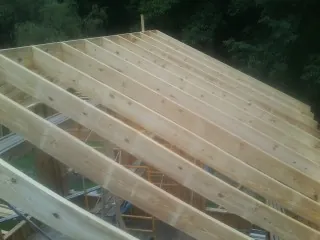 New roof rafters set over an addition before sheathing in Lancaster
